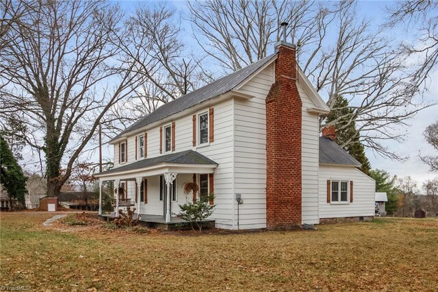 view of side of property with a lawn and a porch