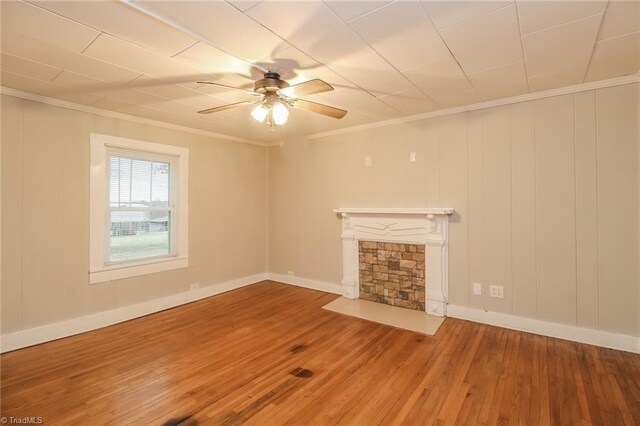 323 Anderson Rd, Eden, NC 27288 - unfurnished living room with a stone fireplace, crown molding, a ceiling fan, and wood finished floors