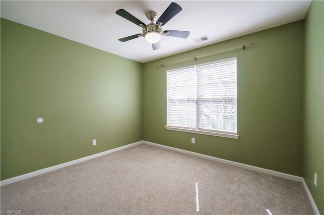 unfurnished room featuring carpet floors, a ceiling fan, visible vents, and baseboards