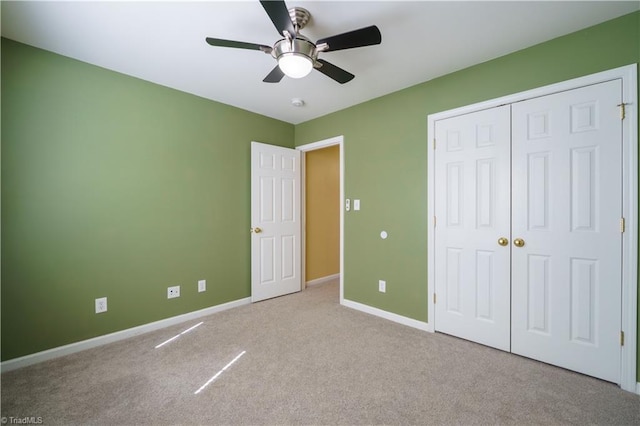 unfurnished bedroom with a closet, carpet, a ceiling fan, and baseboards