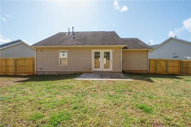 rear view of house featuring a patio area, a fenced backyard, french doors, and a yard