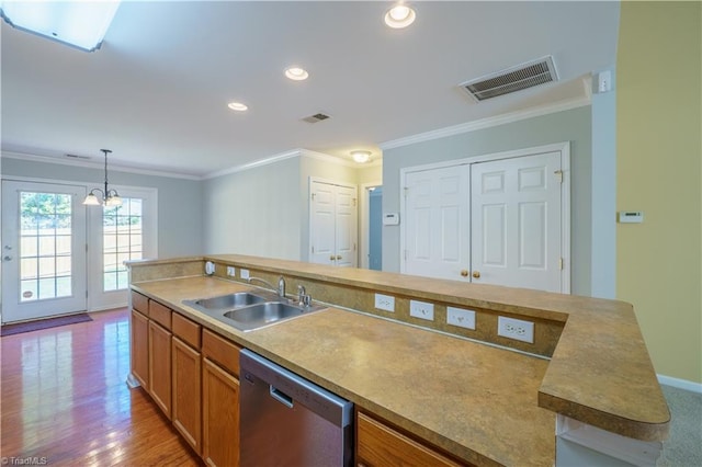 kitchen with crown molding, visible vents, dishwasher, and a sink