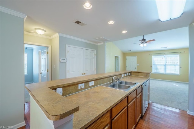 kitchen with crown molding, visible vents, a sink, and stainless steel dishwasher