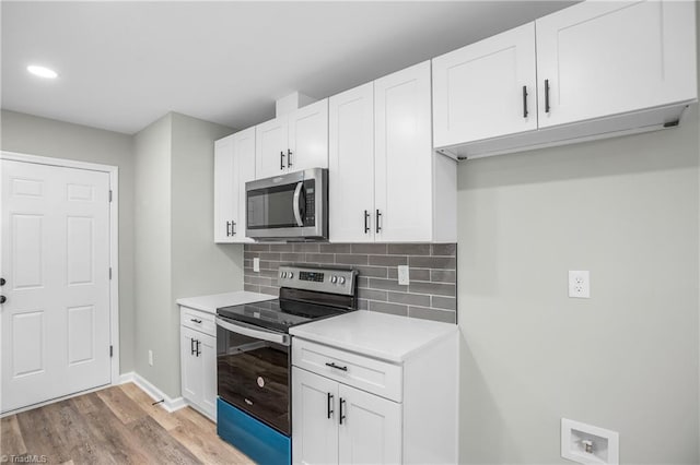 kitchen featuring white cabinets, appliances with stainless steel finishes, light hardwood / wood-style floors, and tasteful backsplash