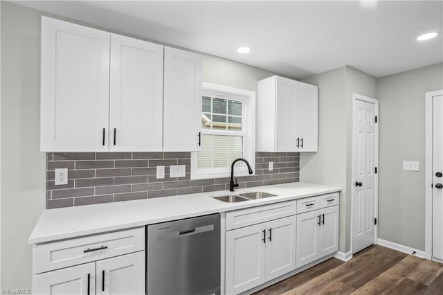 kitchen with white cabinetry, sink, stainless steel dishwasher, dark hardwood / wood-style floors, and backsplash