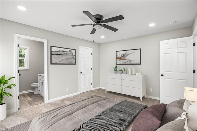 bedroom with ceiling fan, light carpet, and connected bathroom