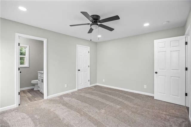 unfurnished bedroom with light carpet, connected bathroom, a closet, and ceiling fan