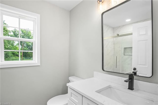 bathroom with vanity, toilet, and a shower with shower door