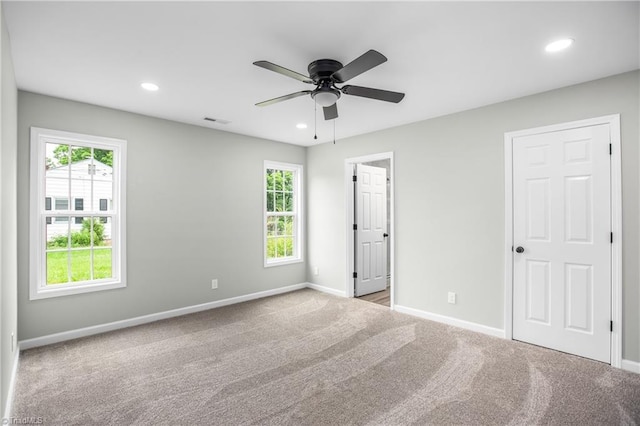 carpeted spare room with ceiling fan