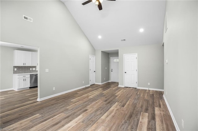 empty room with high vaulted ceiling, ceiling fan, and dark wood-type flooring