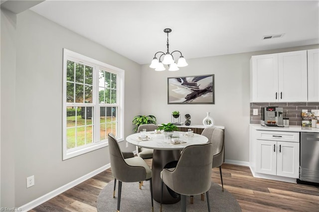 dining space with dark hardwood / wood-style flooring and a notable chandelier