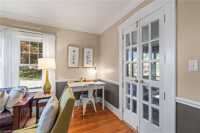 interior space featuring light wood-type flooring, french doors, crown molding, and baseboards