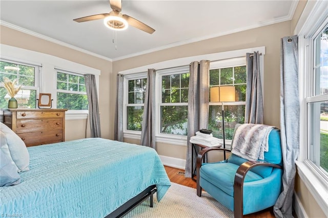 bedroom featuring a ceiling fan, wood finished floors, baseboards, and ornamental molding