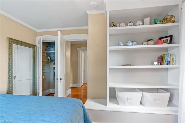 bedroom with crown molding, baseboards, and wood finished floors