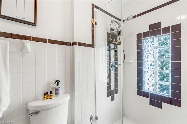 full bathroom featuring toilet, tile walls, and a shower stall