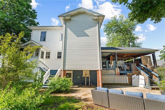 rear view of house featuring outdoor lounge area, a patio area, and stairs