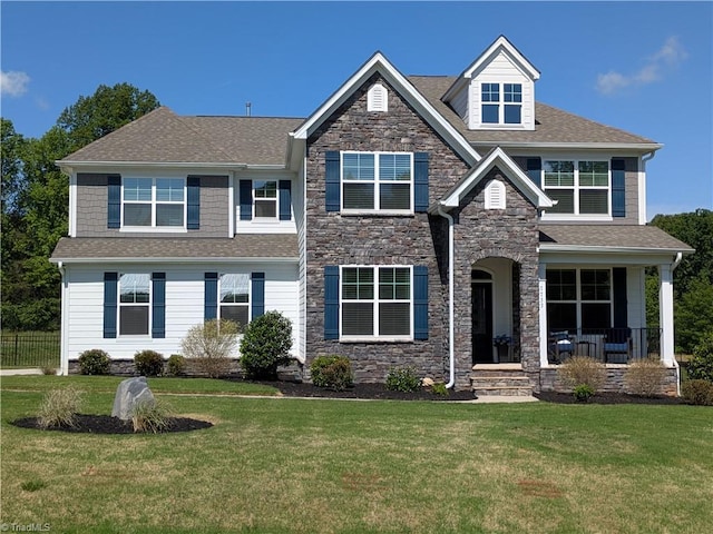 7733 Michaelis St, Greensboro, NC 27455 - craftsman house featuring stone siding, a front lawn, a porch, and roof with shingles