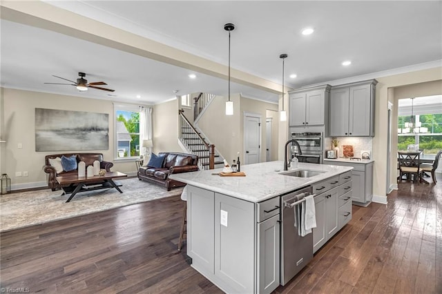 7733 Michaelis St, Greensboro, NC 27455 - kitchen featuring gray cabinets, stainless steel appliances, a sink, ornamental molding, and open floor plan