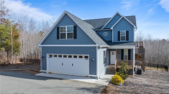 view of front of house with a garage, cooling unit, covered porch, and driveway