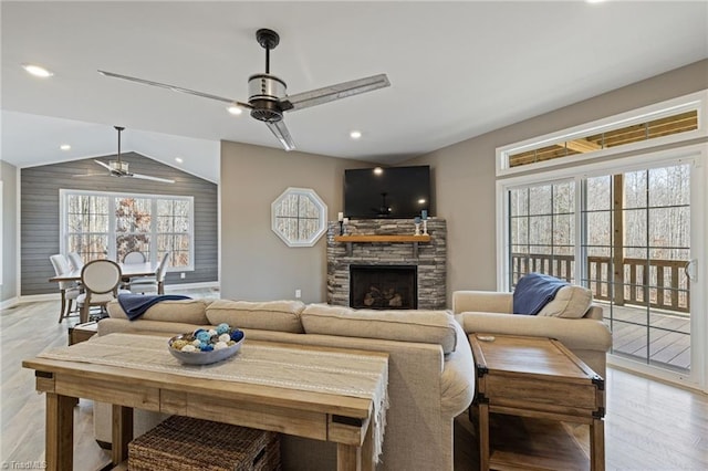 living area featuring ceiling fan, recessed lighting, a fireplace, vaulted ceiling, and light wood-type flooring