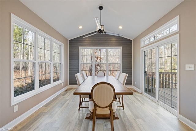 dining area with light wood-type flooring, vaulted ceiling, and plenty of natural light