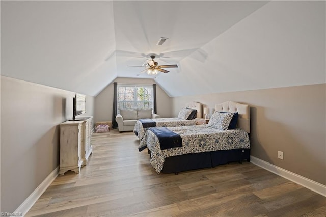 bedroom with visible vents, vaulted ceiling, baseboards, and wood finished floors