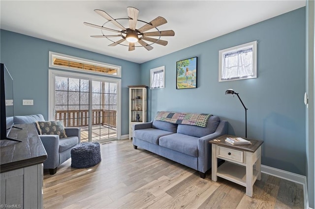 living area featuring ceiling fan, wood finished floors, and baseboards