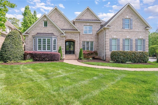 view of front of home with french doors, a front yard, and brick siding