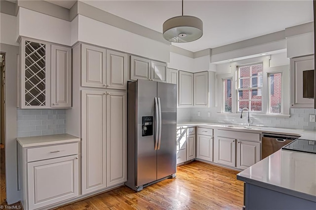 kitchen with sink, decorative backsplash, gray cabinetry, and stainless steel appliances