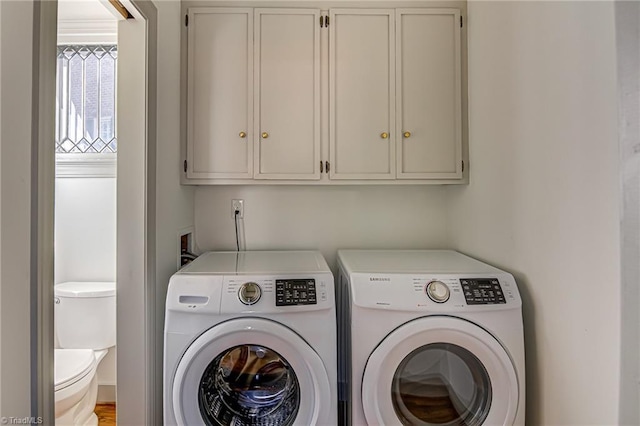 laundry area featuring separate washer and dryer and cabinets