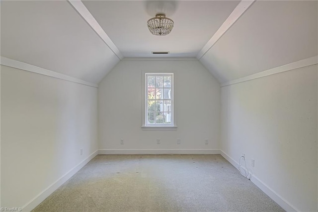 bonus room with light colored carpet and vaulted ceiling