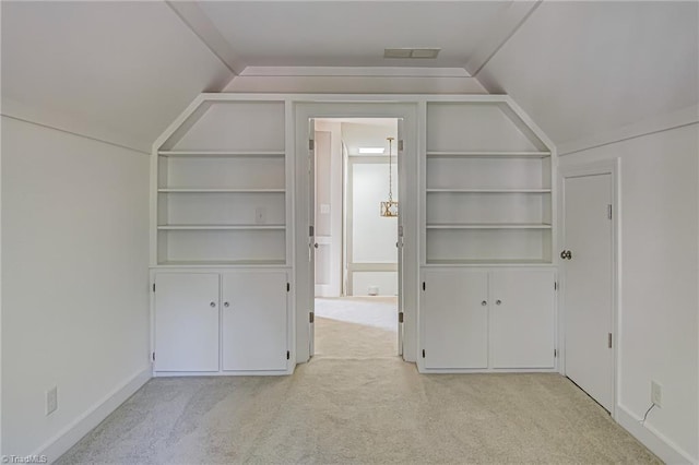 additional living space with built in shelves, light carpet, and lofted ceiling