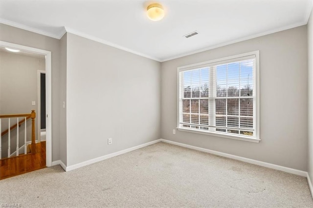 empty room featuring light colored carpet and crown molding