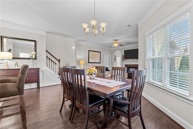 dining space with a wealth of natural light, dark hardwood / wood-style floors, and ornamental molding