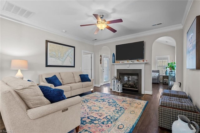 living room with ceiling fan, dark hardwood / wood-style flooring, and ornamental molding