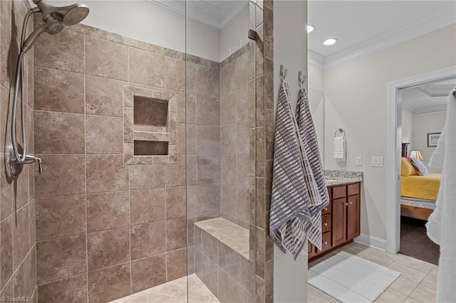 bathroom featuring tile patterned flooring, a tile shower, vanity, and crown molding