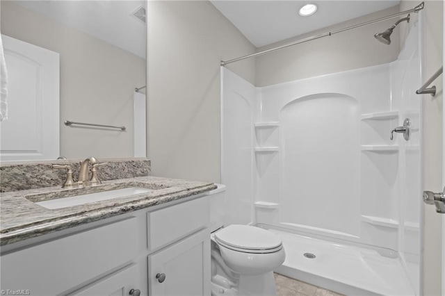 bathroom featuring tile patterned floors, vanity, toilet, and walk in shower