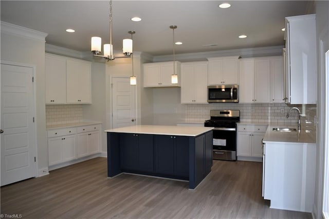 kitchen with stainless steel appliances, a kitchen island, white cabinetry, and sink