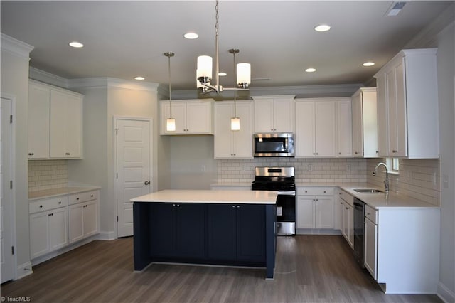 kitchen featuring appliances with stainless steel finishes, dark hardwood / wood-style flooring, sink, a center island, and white cabinetry