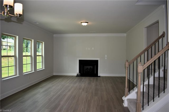 unfurnished living room featuring crown molding, dark wood-type flooring, and an inviting chandelier