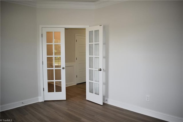 empty room with dark hardwood / wood-style floors, crown molding, and french doors