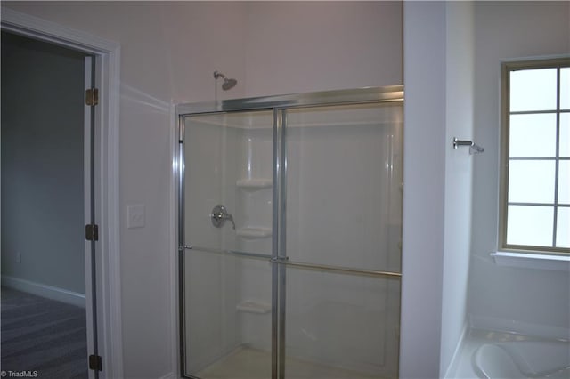 bathroom with independent shower and bath and a healthy amount of sunlight