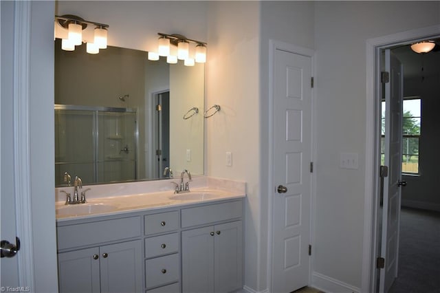 bathroom with vanity and a shower with door