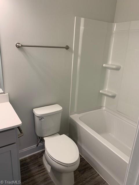 full bathroom featuring toilet, vanity, shower / tub combination, and hardwood / wood-style floors