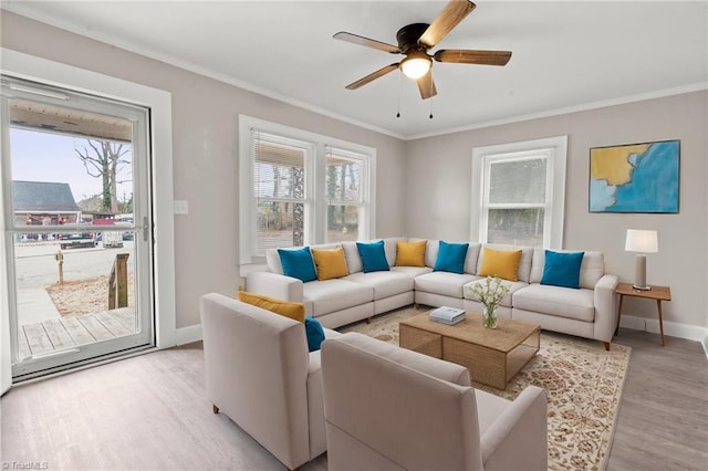 living room with ceiling fan, crown molding, and light hardwood / wood-style floors