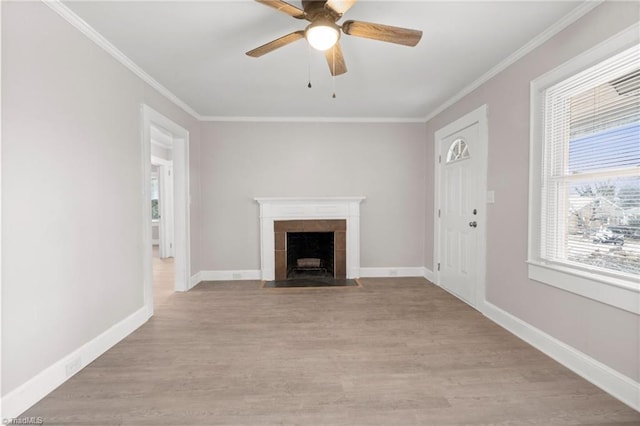 unfurnished living room with ceiling fan, light wood-type flooring, crown molding, and a fireplace