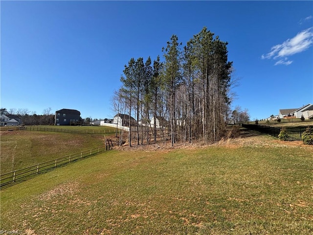 view of yard with a rural view and fence