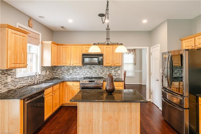 kitchen with pendant lighting, stainless steel appliances, a center island, and dark hardwood / wood-style floors