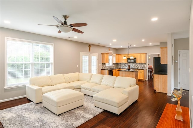 living room featuring ceiling fan, a healthy amount of sunlight, and dark hardwood / wood-style flooring