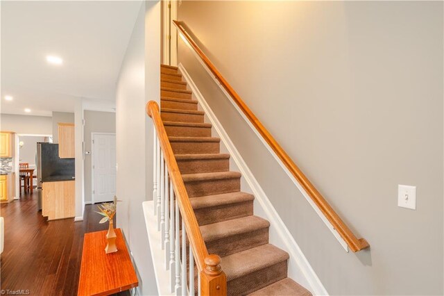 stairs featuring hardwood / wood-style floors